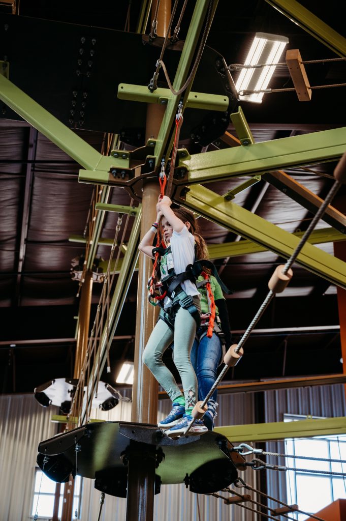 girl climbing high on the ropes course